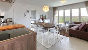 Una cucina moderna con zona pranzo, divano e un'ampia finestra che offre una vista.
