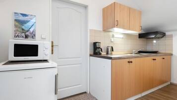 Kylskåp, mikrovågsugn, grytor/köksredskap och matbord