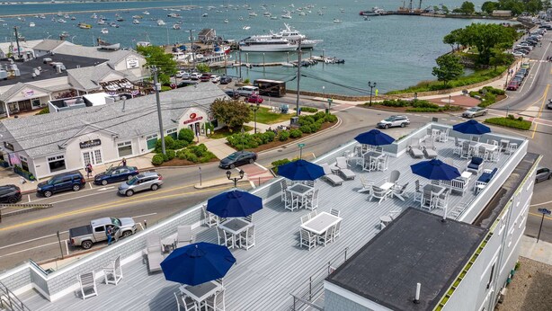 Un hotel sul lungomare con posti a sedere all'aperto e vista sul porto turistico.
