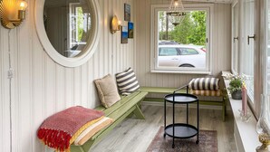 A cozy room with a green bench, a small round table, and a window with a view of a car outside. - 2 bedroom lovely home in Gislaved (Gislaved)