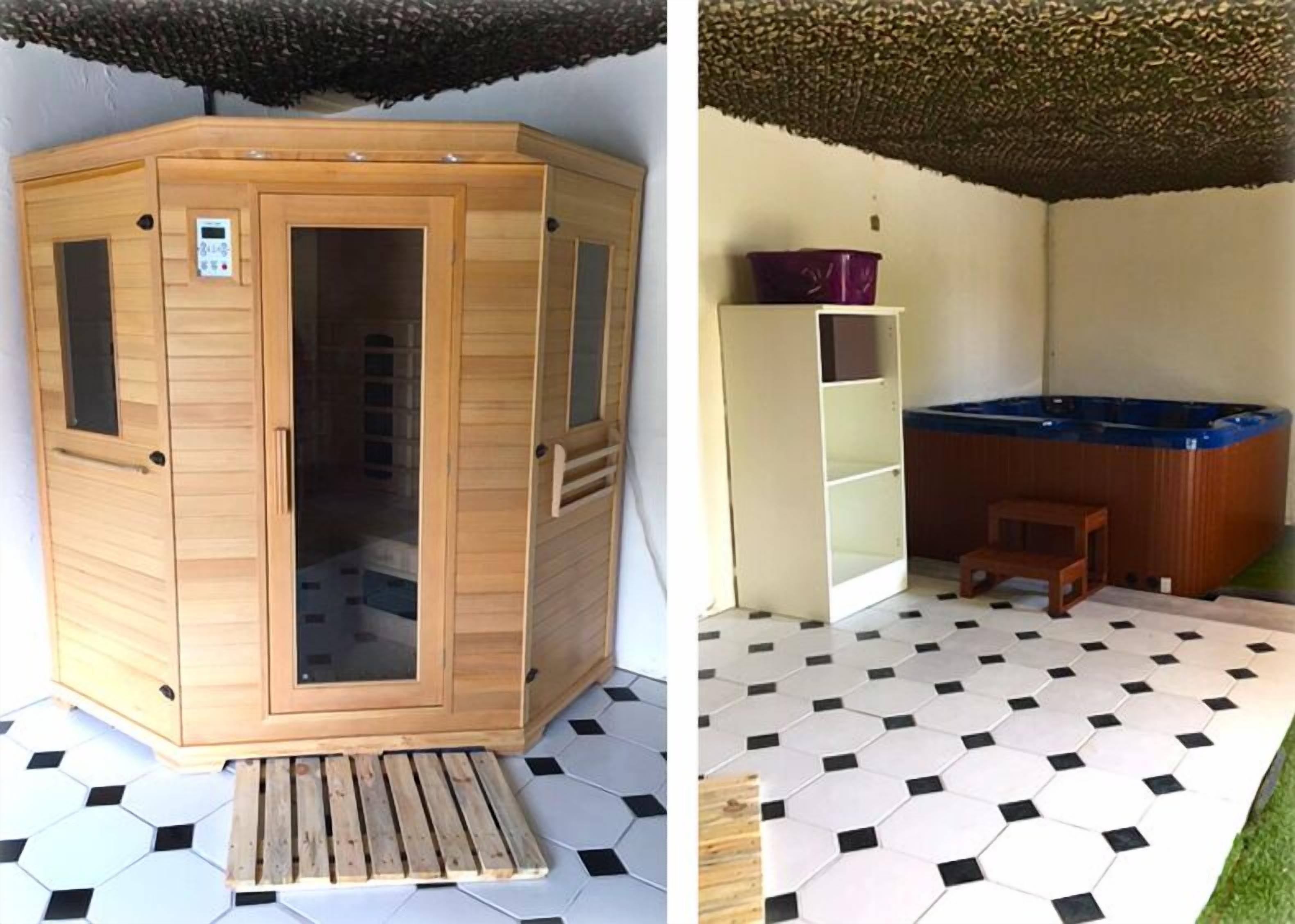 A wooden sauna with a control panel, a wooden bench, and a hot tub in a room with hexagonal tiled flooring.
