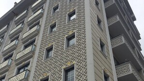 Un edificio de gran altura con una fachada geométrica distintiva y balcones.