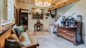 Ein gemütliches Wohnzimmer mit einem Holzsofa, einer Kristallleuchtre, einer Uhr und einem dekorativen Schrank.