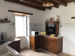 A kitchen with wooden cabinets, a microwave, a toaster, and a sink.