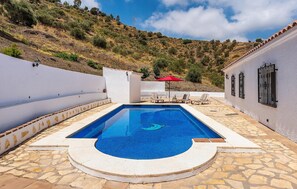 Een buitenzwembad en ligstoelen