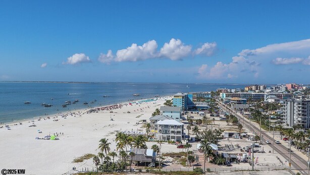 Blick auf einen Sandstrand, das Meer und Gebäude.