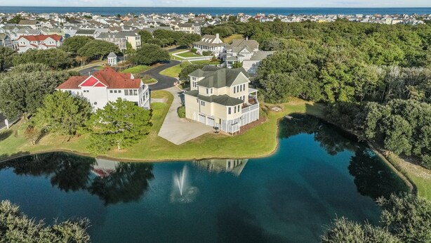 A large estate with a lake, surrounded by trees and a view of the ocean. - 1603 - Bare Feet Retreat - Pet-Friendly Corolla Retreat Near the Beach (Corolla)
