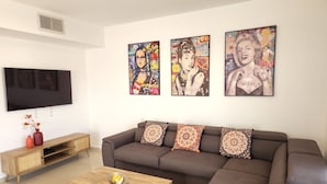 A modern living room with a sectional sofa, a wooden coffee table, and a flat-screen TV mounted on the wall. - Melony Apartents Eilot Street Al Hyam (Eilat)