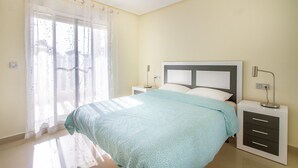 A bedroom with a bed, two bedside tables, a window with sheer curtains, and a wall-mounted light fixture. - 5 bedroom gorgeous home in El Campello (El Campello)