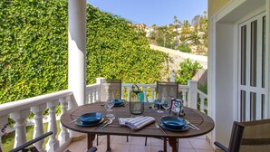 A round table set for two on a balcony with white railings, overlooking a lush green hillside. - 5 bedroom gorgeous home in El Campello (El Campello)