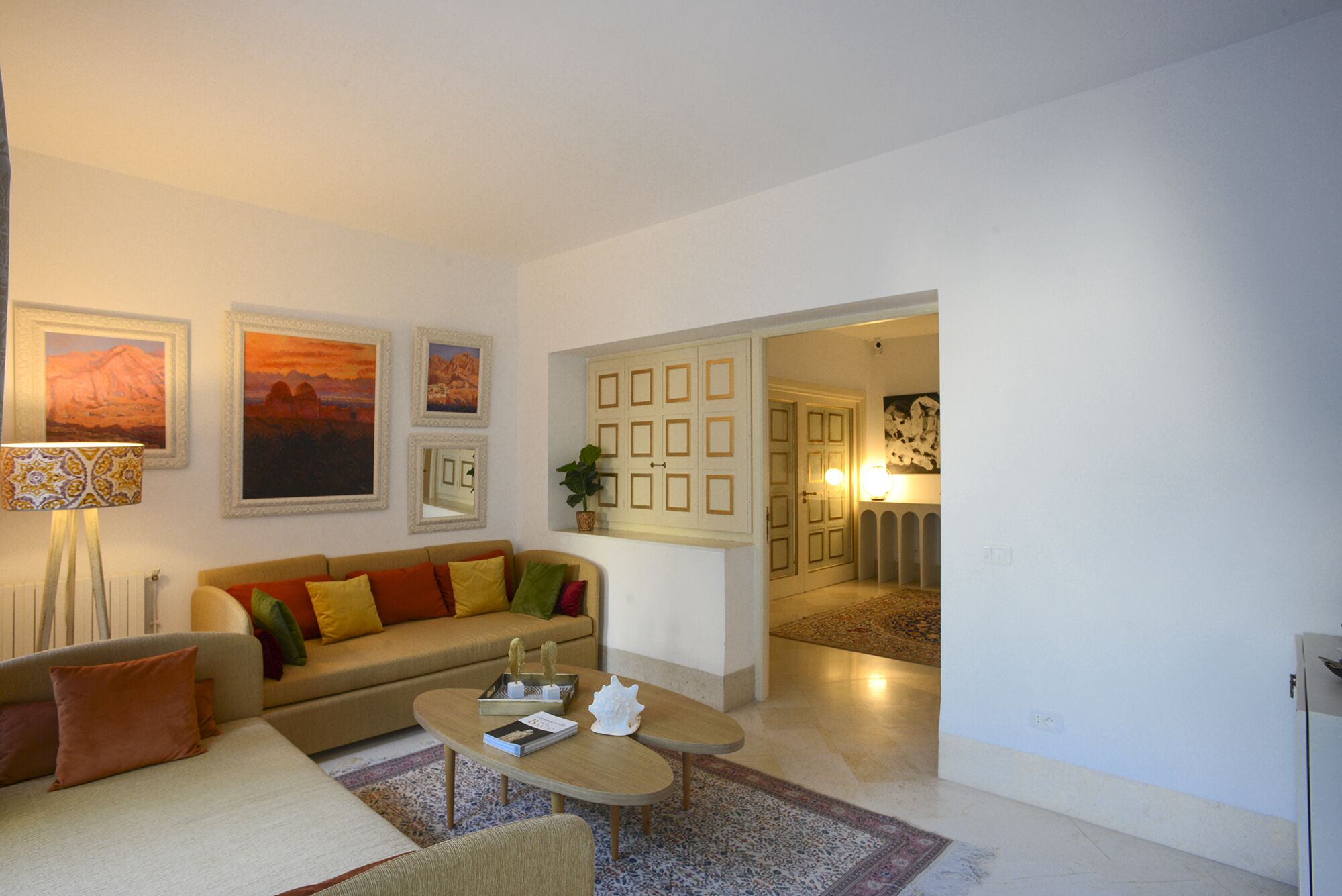 A living room with a sofa, coffee table, and framed pictures on the wall.