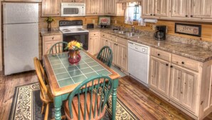 A kitchen with wooden cabinets, a microwave, a stove, and a coffee maker.