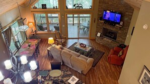 A spacious living area with a fireplace, a television, and a dining area with a table and chairs.