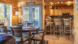 L’intérieur d’un chalet en bois comprend un coin repas, une cuisine et un panneau indiquant l’emplacement.