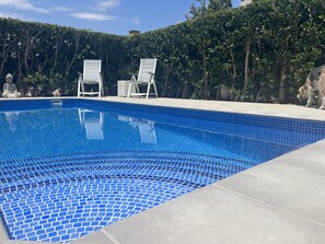 A swimming pool with blue mosaic tiles, surrounded by a hedge and two white lounge chairs. - Beautiful Villa with pool (Torre-Pacheco)
