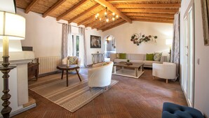 A spacious living room with a high wooden ceiling, a sofa set, a coffee table, and a patterned rug. - Quinta Molinum Ad Mare | 8 Bedrooms | Sea Views | Boliqueime (Boliqueime)