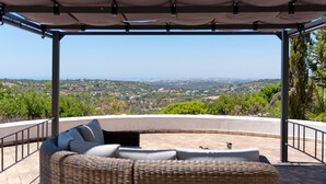 A covered outdoor seating area with a view of a hilly landscape. - Quinta Molinum Ad Mare | 8 Bedrooms | Sea Views | Boliqueime (Boliqueime)