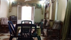 A room with a checkered floor, a television, and several chairs and sofas. - A 3-BR apt w FP, GV & 20 min to the sea & Muntazah (Al Mandarah Qebli, Montaza 2)