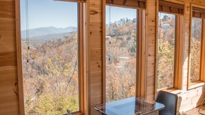 A wooden cabin with large windows offering a view of a mountainous landscape. - 4King Suites | Hot Tub | Game Room | Sunrise Views (Gatlinburg)