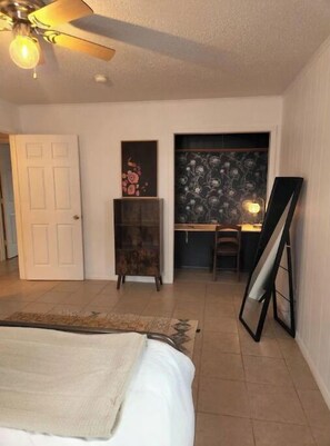 Cozy retreat with a bed, desk, and mirror, perfect for a comfortable stay.
