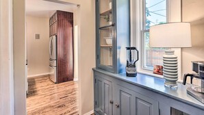A kitchen with a refrigerator, a cabinet with a glass door, a blender, and a coffee maker. - Milwaukee Home < Half Mi to Lake Michigan! (Milwaukee)