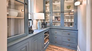 A kitchen with a built-in cabinet, a coffee maker, and a window. - Milwaukee Home < Half Mi to Lake Michigan! (Milwaukee)