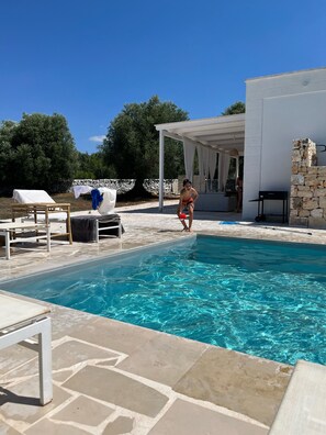 A swimming pool with lounge chairs and a covered area. - Bianchemura Mansion (Ostuni)