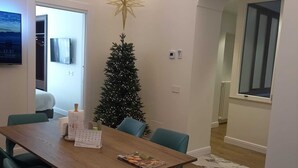 A dining area with a wooden table, teal chairs, a Christmas tree, and a star decoration. - Appartamento nel Centro Storico di Sorrento, Nuovo, con Vista (Sorrento)