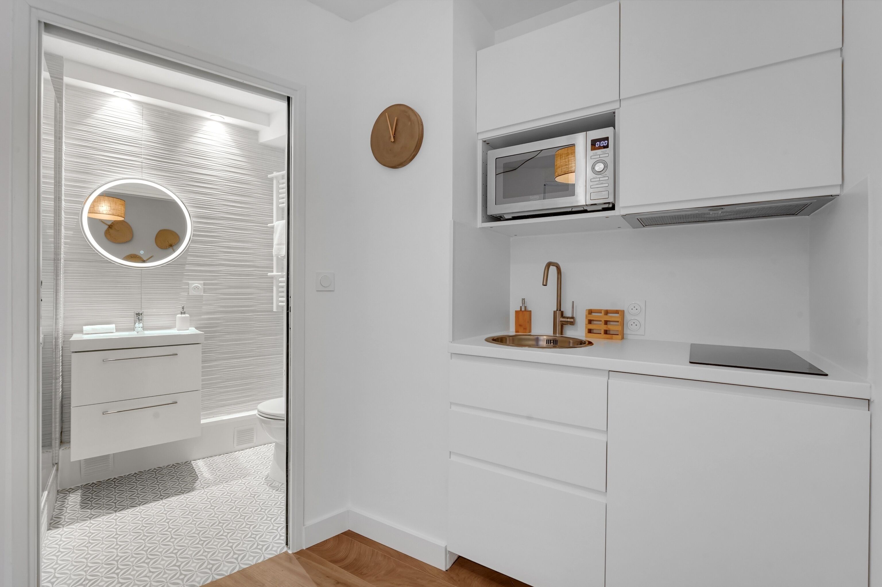 Uma casa de banho moderna com sanita, lavatório e espelho.