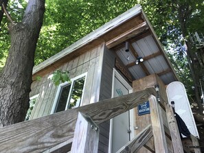 Ein rustikales Holzhäuschen mit Holzwand, einer sichtbaren Tür und einem Schild mit der Aufschrift 'Lake Life'.