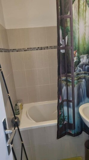 Een bad, een haardroger, handdoeken, toiletpapier
