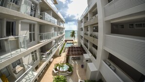 Um hotel moderno com vários andares, piscinas ao ar livre e vista para o oceano.