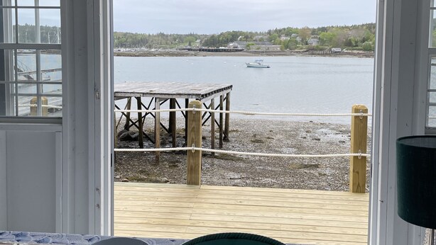 A room with a view of a waterfront, a wooden dock, and a starfish decoration. - Historic Oceanfront Home with private dock and boat house. Walkable to town. (Southwest Harbor)