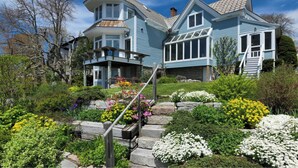 A large, two-story house with a prominent tower and a covered porch. - Historic Oceanfront Home with private dock and boat house. Walkable to town. (Southwest Harbor)
