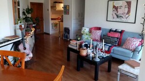 A living room with a sofa, coffee table, and a dining area with a table and chairs. - Great location in Barrio Italia, Providencia (Santiago)