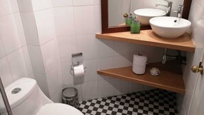 A compact bathroom with two sinks, a toilet, and a small trash bin. - Great location in Barrio Italia, Providencia (Santiago)