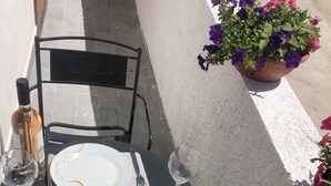 A table set for two with wine glasses, plates, cutlery, and a bottle. - Appartamento nel Cuore Della Costa Damalfi (Pietre)