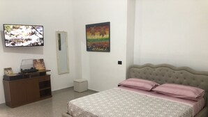 A bedroom with a bed, a dresser, a television, a mirror, and a painting on the wall. - Appartamento nel Cuore Della Costa Damalfi (Pietre)