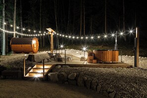 A wooden cabin with a hot tub, deck, and string lights. - A_AL RANCH WELLNESS Cortina, Lake Cadore, Dolomites (Pozzale)