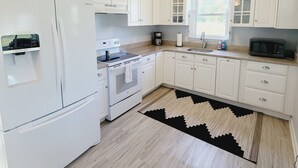 A modern kitchen with white cabinetry, a built-in oven, a microwave, and a coffee maker. - WATERFRONT!! **HOT TUB**  3 bedroom Oasis on 2+ acres - Sleeps 8 (Cambridge)