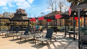 An outdoor patio with sun loungers and a gazebo.