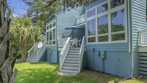 A two-story house with a covered porch and a staircase leading to the upper floor. - Pet Friendly, 3Bed, easy walk to Pool, Beach, Restaurants, Golf N Pickle Ball  (Edisto Island)