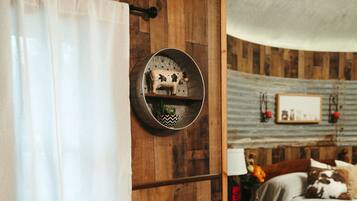 A wooden bathroom with a toilet, a sink, and a shower curtain.