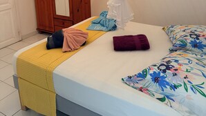 A bedroom with a bed, a canopy, a wardrobe, and a window with blinds. - À 10 mn à Pied de la Plage, T3 Jardin vue mer (Les Anses-d'Arlet)