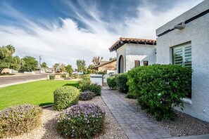 Green grass and lush desert plants welcome you to Red Doors 