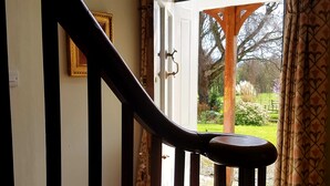 Un escalier avec une rampe en bois menant à une porte dotée d’une vitre.