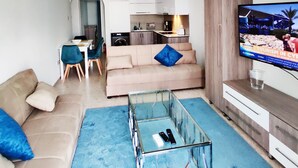 Ein modernes Wohnzimmer mit einer Couch, einem Couchtisch und einem Fernseher.