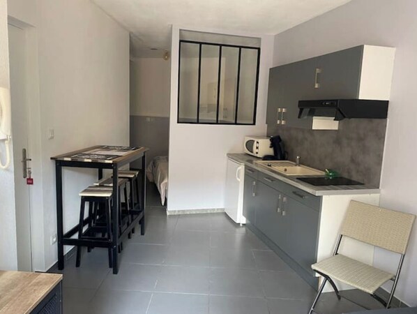 A compact kitchen with a dining area, a microwave, and a sink.