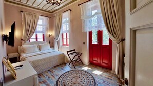 Un dormitorio con cama, mesita de noche, lámpara y una puerta roja.