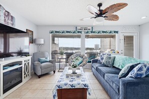 A living room with a ceiling fan, a sofa, a coffee table, and a TV. - Fun N Sun Lake Travis Waterfront Condo 104 Boat Slip Available (Spicewood)
